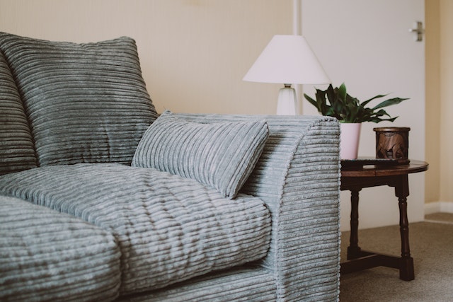 grey couch with dark wood side table